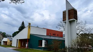 Modernes, farbenfrohes Kirchengebäude mit separatem Kreuzturm.