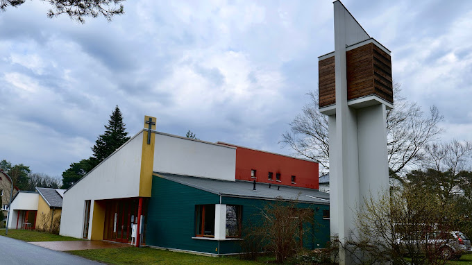 Modernes, farbenfrohes Kirchengebäude mit separatem Kreuzturm.
